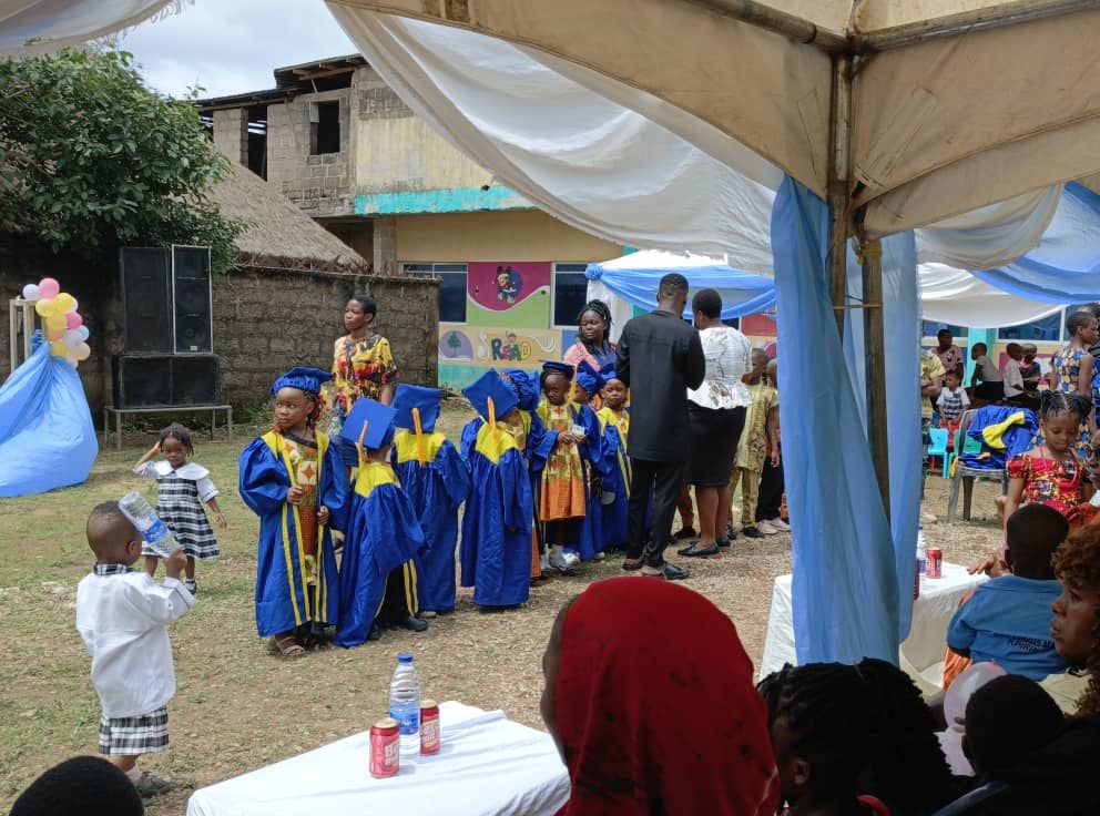Pupils in royal blue and gold graduation gowns celebrating together